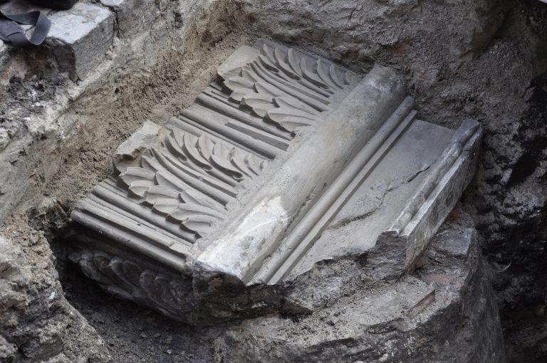 Foto van Het gebeeldhouwde zandsteenwerk dat op een putdeksel onder de bestrating van de Grote Kromme Elleboog werd aangetroffen. 