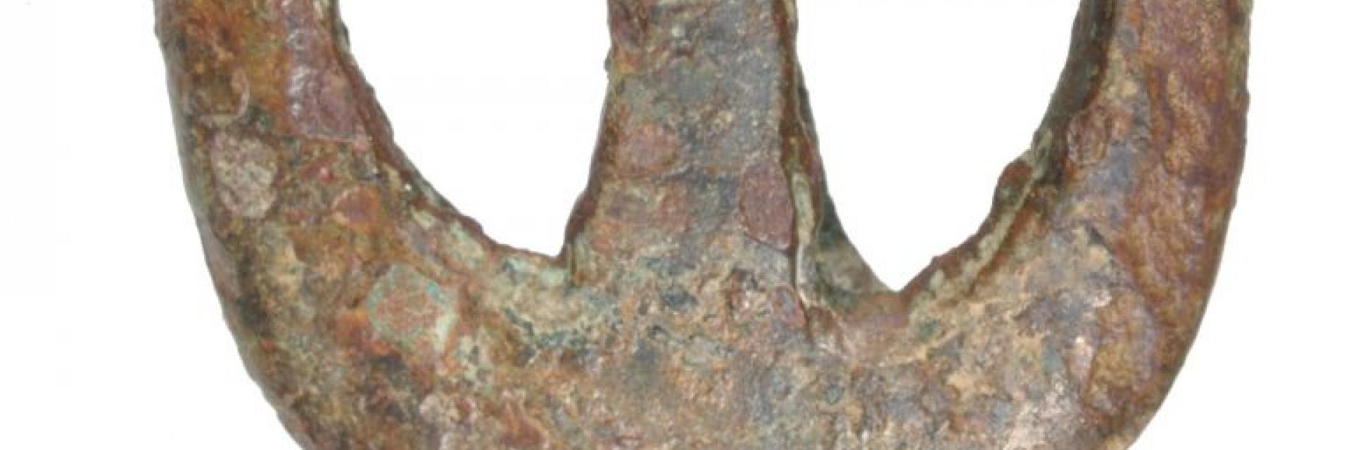 Foto van gedecoreerde bronzen zwaardschedebeschermer uit de 13de eeuw.